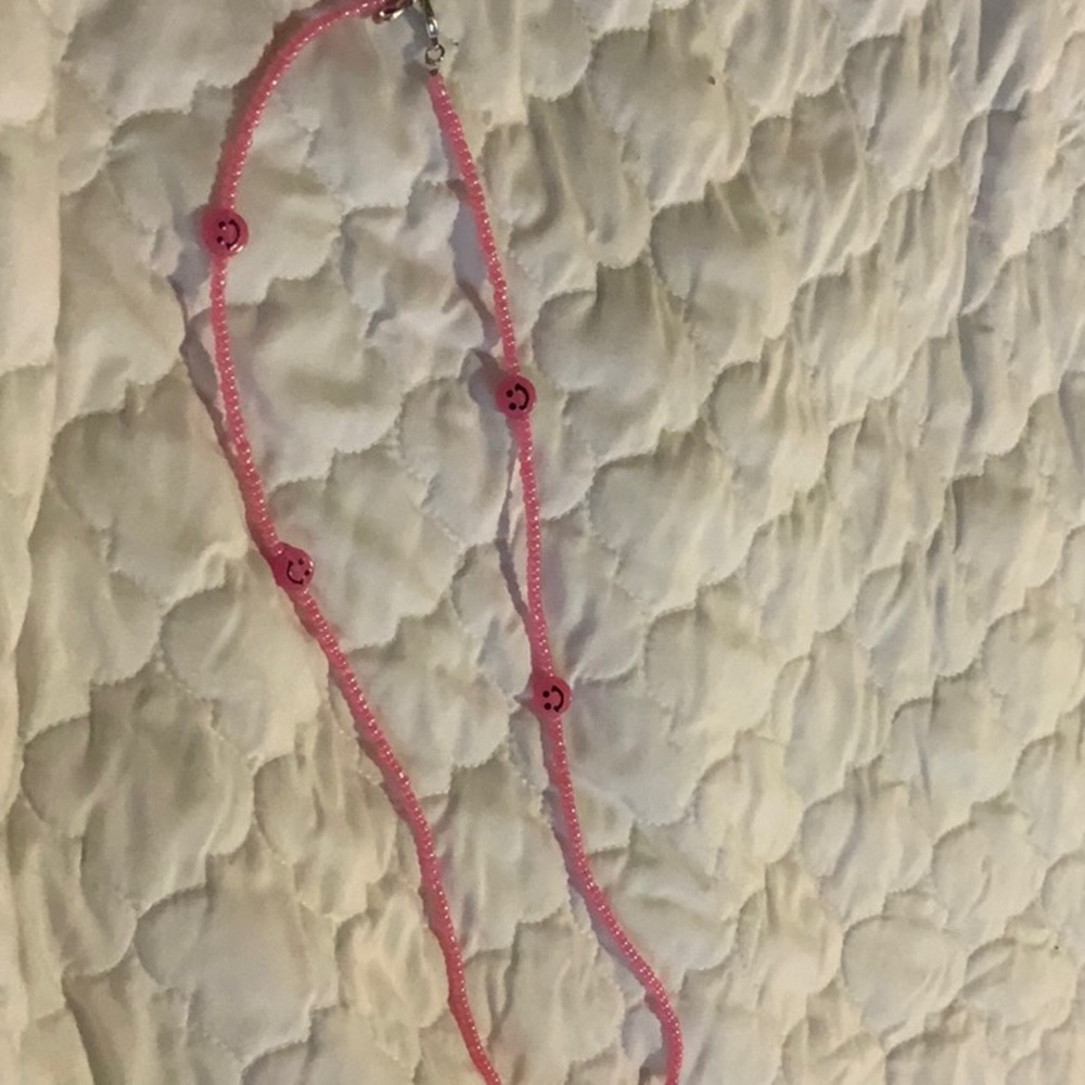 I am selling a pink smiley necklace.
